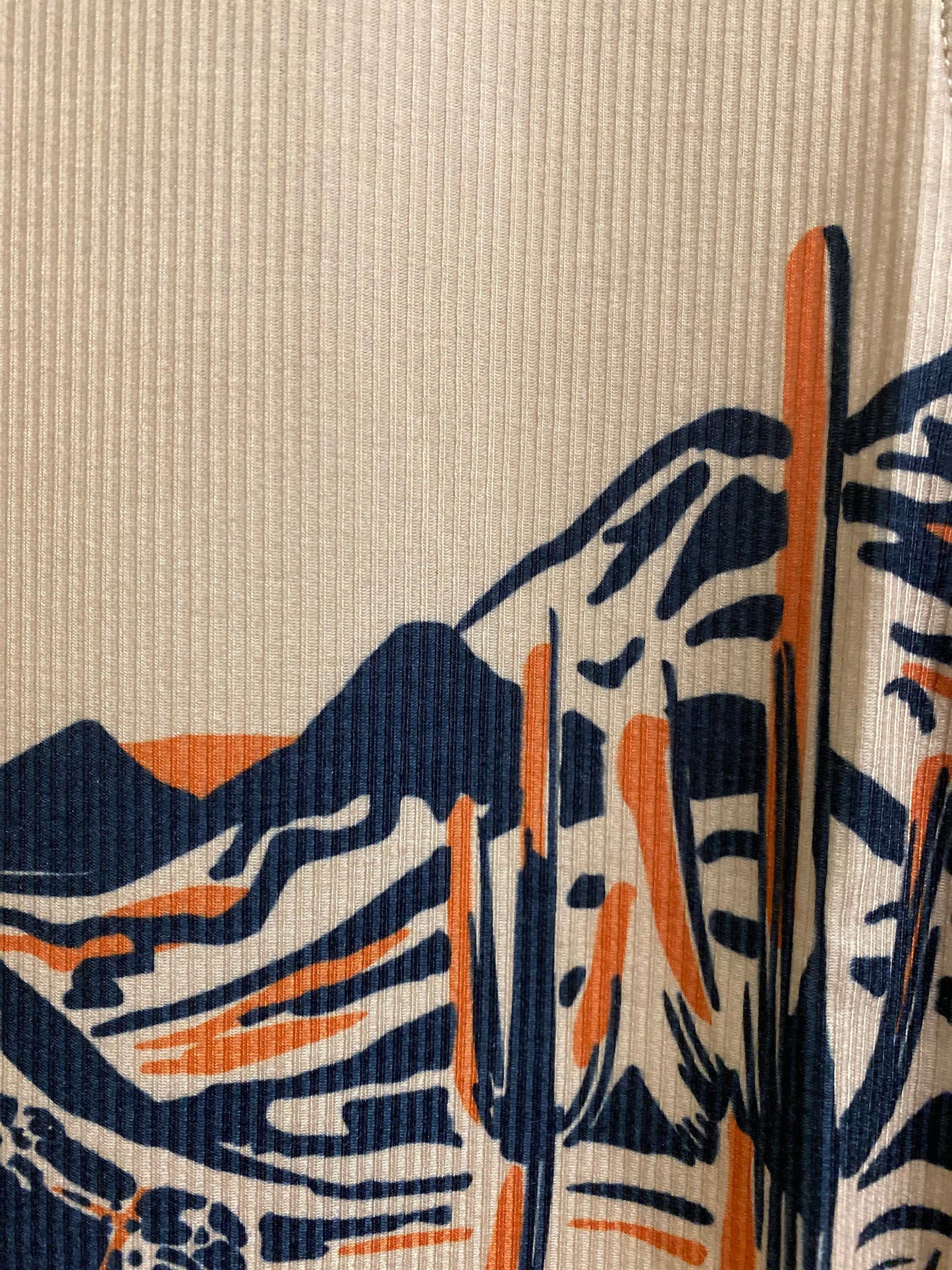 Close-up of a light brown shirt with artwork depicting desert hills and cacti